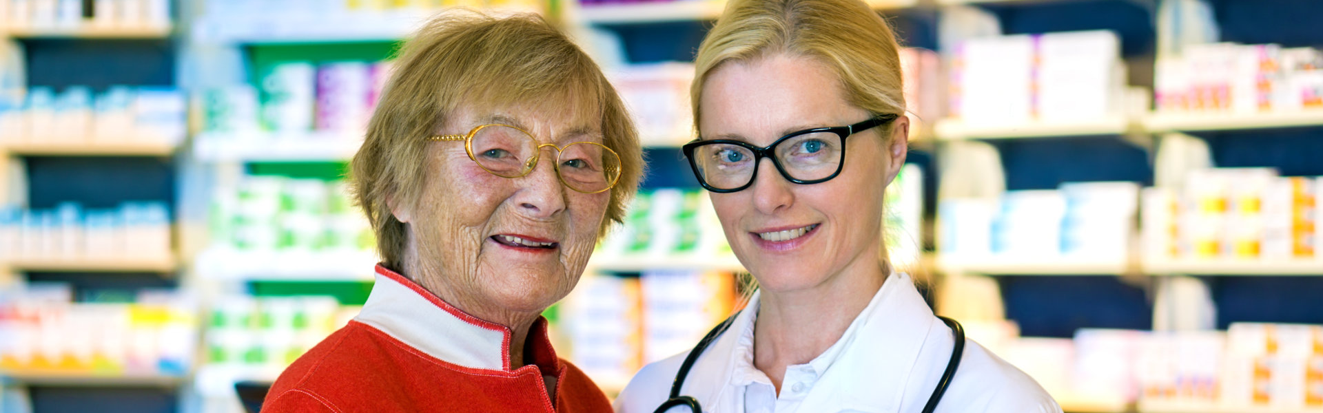 pharmacists and elderly woman smiling